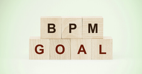 letters bpm and word goal on wooden cubes on light green