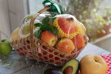Fruit in handmade basket on wooden background,