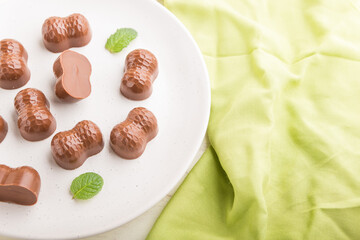 Chocolate candies with almonds on a white wooden background. side view, selective focus