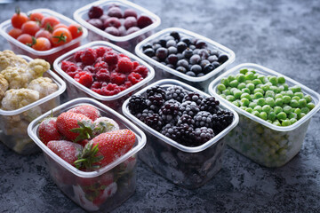 Variety of frozen berries in boxes on a gray background