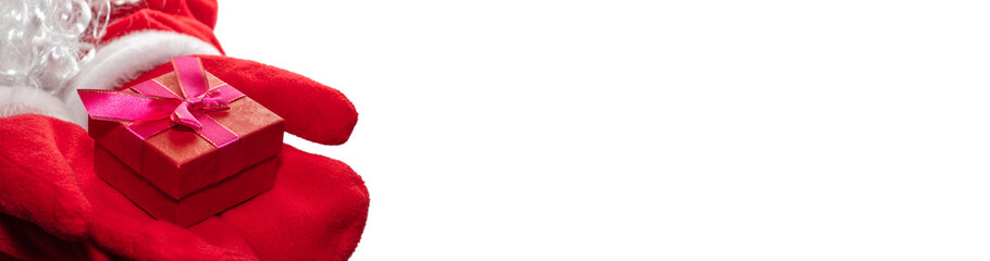 High angle close up shot of Santa Claus's hands holding a red gift box with a purple ribbon. Christmas gift concept. Banner size, copy space. Isolated on white background