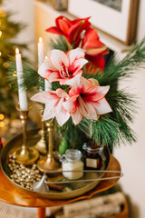 Christmas candles on a table with flowers and pine