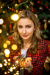 Girl with lights sitting on the background of Christmas tree at home, Happy New Year 2021