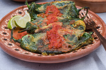 Traditional mexican stuffed peppers chiles rellenos on mexican clay plate