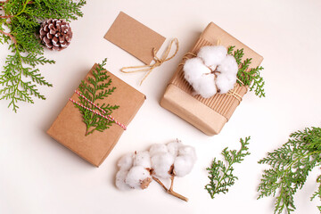 Two boxes with Christmas gifts, and juniper twigs. New year concept. Flat lay style