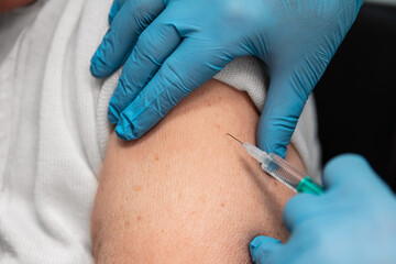 close up of an elderly adult woman, getting a vaccination