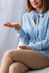 Cropped view of female psychologist gesturing while sitting on chair in office