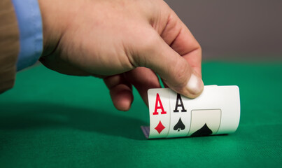 Close-up of an adult man's hand in a casino holding a winning card combination