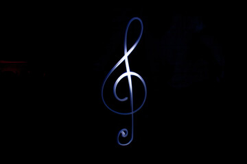 treble clef created with light in a dark room