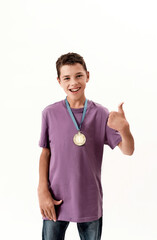 Happy teenaged disabled boy with cerebral palsy wearing gold medal, smiling and showing thumbs up...