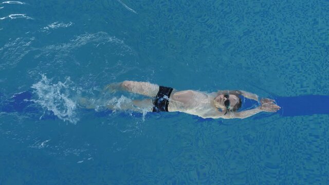 Caucasian Child Backstroking in Pool. Swimming Training and Sports Activity