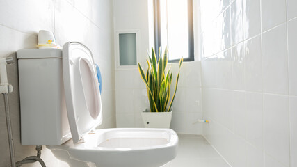Fototapeta na wymiar White bathroom overlooking the windowed toilet with orange light.