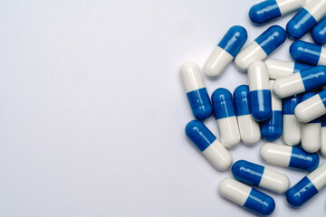 Heap of pills capsules over light grey background