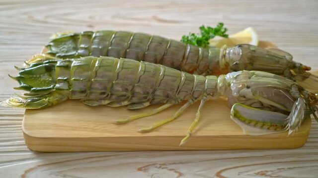 fresh mantis shrimp with lemon on wood board