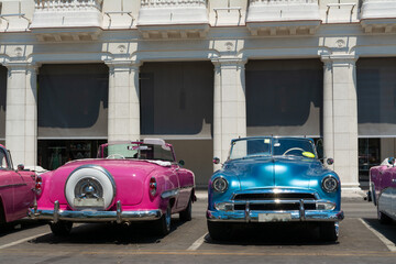 La Habana, Cuba, hay varios autos clásicos estacionados a un lado del Hotel Manzana en La Habana Vieja.