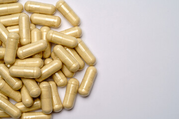 Heap of pills capsules over light grey background