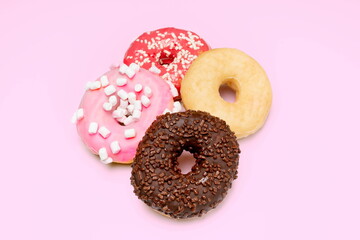 Four delicious round candies on pink background