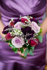 shades of purple bridesmaid bouquet with purple satin dress background