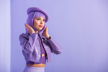 young woman dressed in doll style in beret posing on violet colorful background