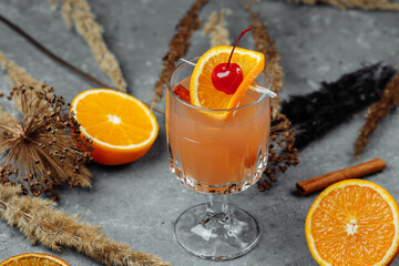 Mulled wine in glass glasses with apples orange and cinnamon. Hot Christmas drink on a grey...