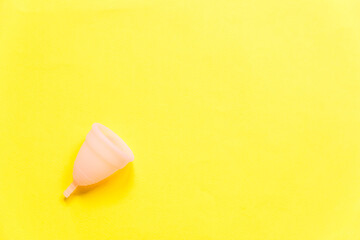 Simply minimal design pink menstrual cup Isolated on yellow background. Woman modern alternative eco gynecological hygiene in menstruation period. Container for blood. Flat lay top view, copy space
