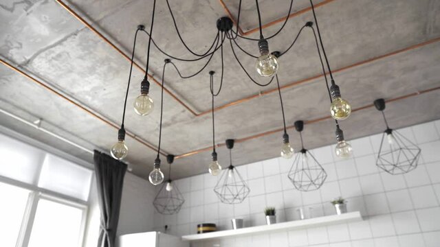 Decorative antique edison light bulbs with straight wire. Big vintage incandescent light bulbs hanging in modern kitchen. Inefficient filament light bulbs waste electricity. Dimmable, warm white, E27