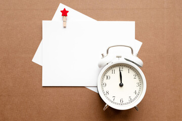 mock up blank white sheet, white alarm clock on isolated background with place for text christmas...