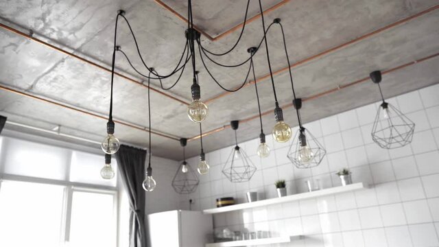 Decorative antique edison light bulbs with straight wire. Big vintage incandescent light bulbs hanging in modern kitchen. Inefficient filament light bulbs waste electricity. Dimmable, warm white, E27
