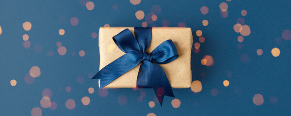 Blue theme craft gift box present with classic blue ribbon and copy space, holiday, xmas, christmas 2020. Shopping, sale banner, flyer, coupon concept, father, dad day, birthday, valentine, wedding - obrazy, fototapety, plakaty