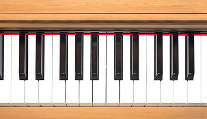 Closeup of piano keys and wood grain with yellow tone