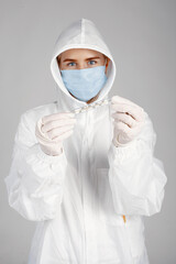 Doctor in a medical mask. Coronavirus theme. Isolated over white background. Woman in a protective suit.