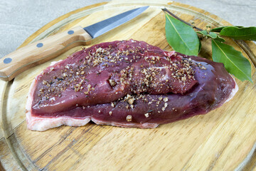 magret de canard cru au sel de guérande sur une planche à découper