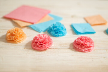 Close-up crafting flowers from paper close-up with little boy hand
