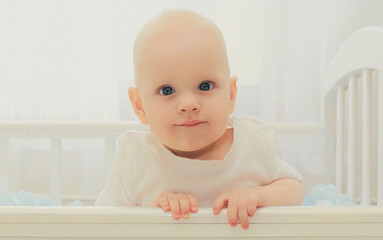 Portrait of cute baby sitting in the bed at home