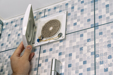the master cleans the ventilation in the bathroom