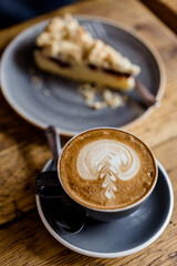 Cup of hot Cappuccino coffee on wooden table at cafe. with Cake Fresh invigorating drink