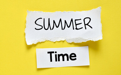 The word Summer time on a white sheet and yellow background. Time for vacation.