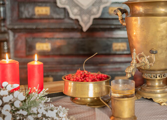 Retro tableware made of brass, candles, viburnum berry, christmas eve