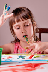 The process of painting, art, learning to draw concept. Young beauutiful girl painted in bright...