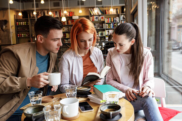 Group of university students hangout in college cafe library and preparing for lecture.	