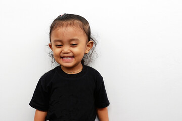 Little girl expression wearing a black t-shirt isolated on white background.