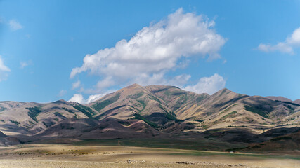 Photo of Summer Sandy Hills Landscape. Travel Mountain location of popular tourist attraction. View of beautiful nature Desert on Cloudy Sky Background