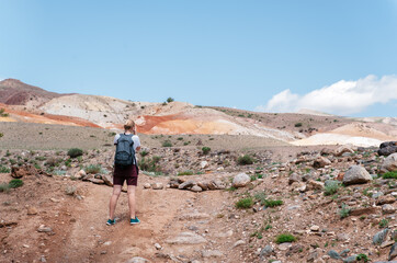 Young Tourist Girl and Summer Sandy Hills Landscape. Travel Mountain location of Popular Attraction. View of beautiful nature Desert on Cloudy Sky Background