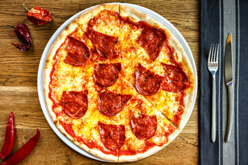 Pizza Pepperoni served on a wooden table in trattoria italiana