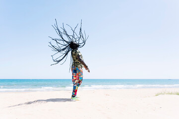 Rastafari man tossing his dreadlocks on the beach