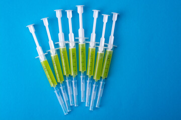 Several syringes with a vaccine on a blue background. View from above.