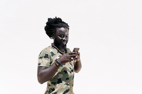 Man with dreadlocks using smartphone