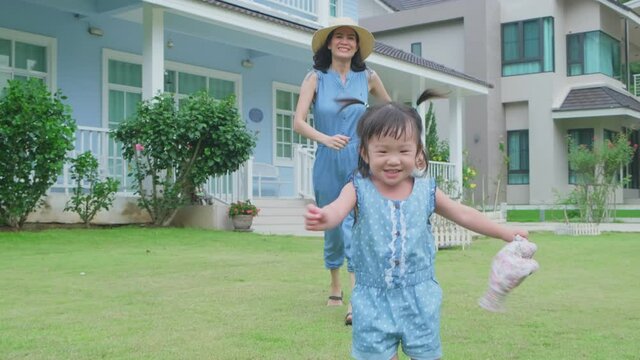 Asian young mother happy to see her daughter walking fluently.