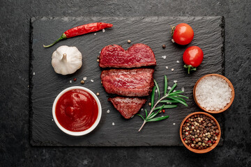 Three pieces of meat. three types of roast meat, rare, medium, well done in the shape of a heart on a stone background