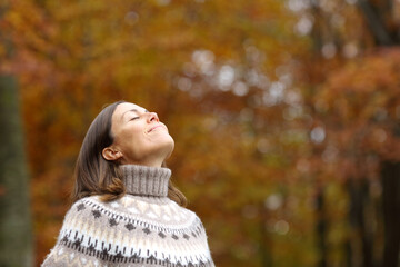 Middle age woman breathing deep fresh air in autumn